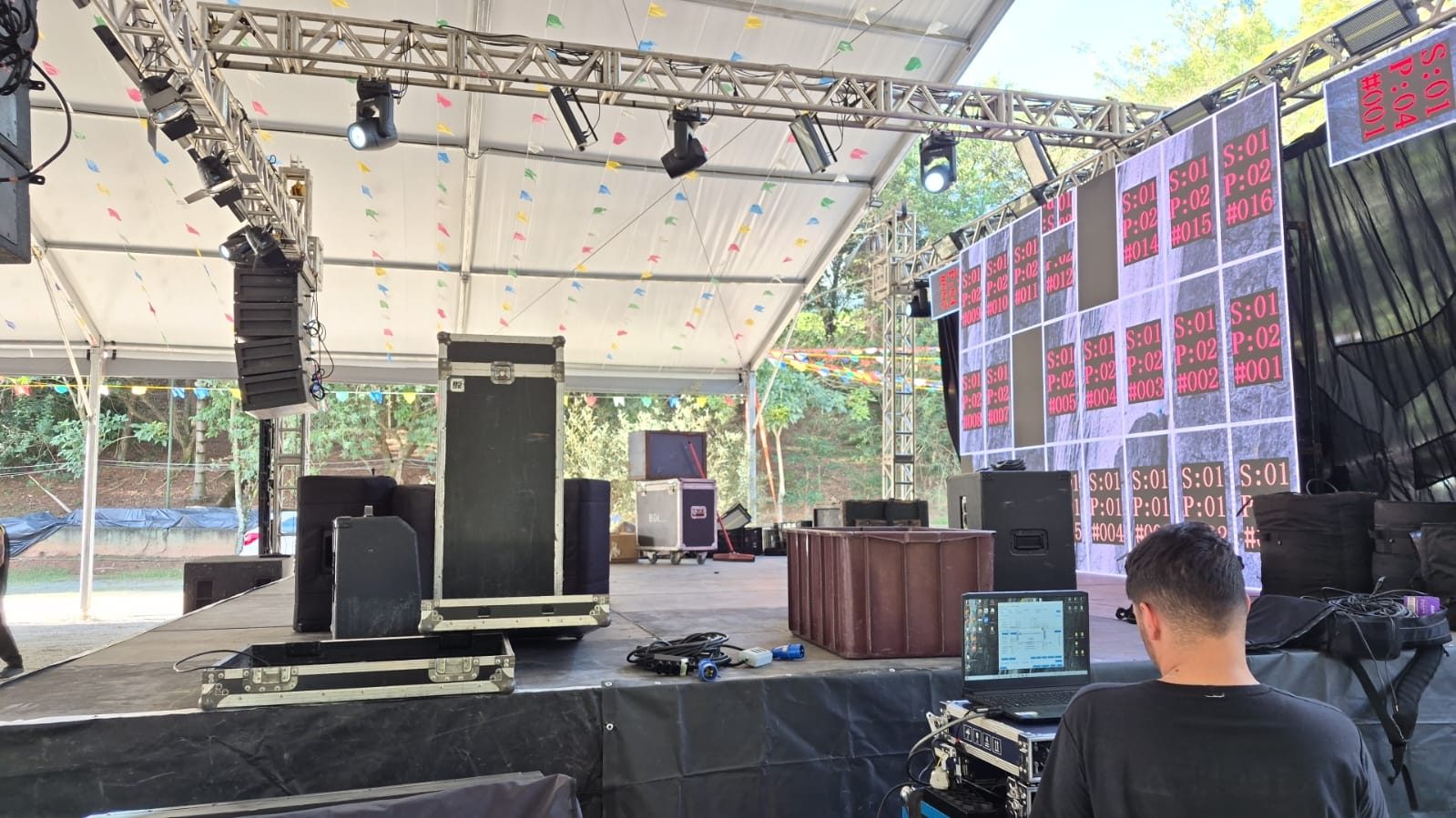 Montagem de palco coberto com painel de LED, moving heads e sonorização para festival em área externa